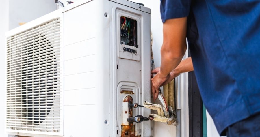 man installing air conditioning unit outside