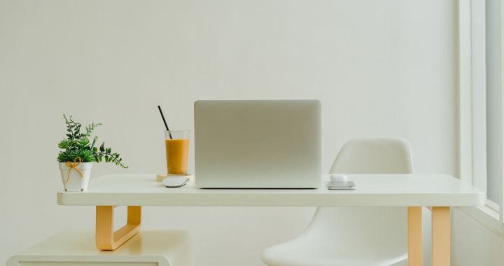 office desk with a drink, laptop and plants