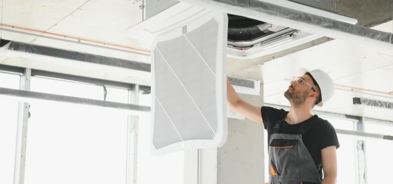 air conditioning engineer repairing ceiling cassette air conditioner