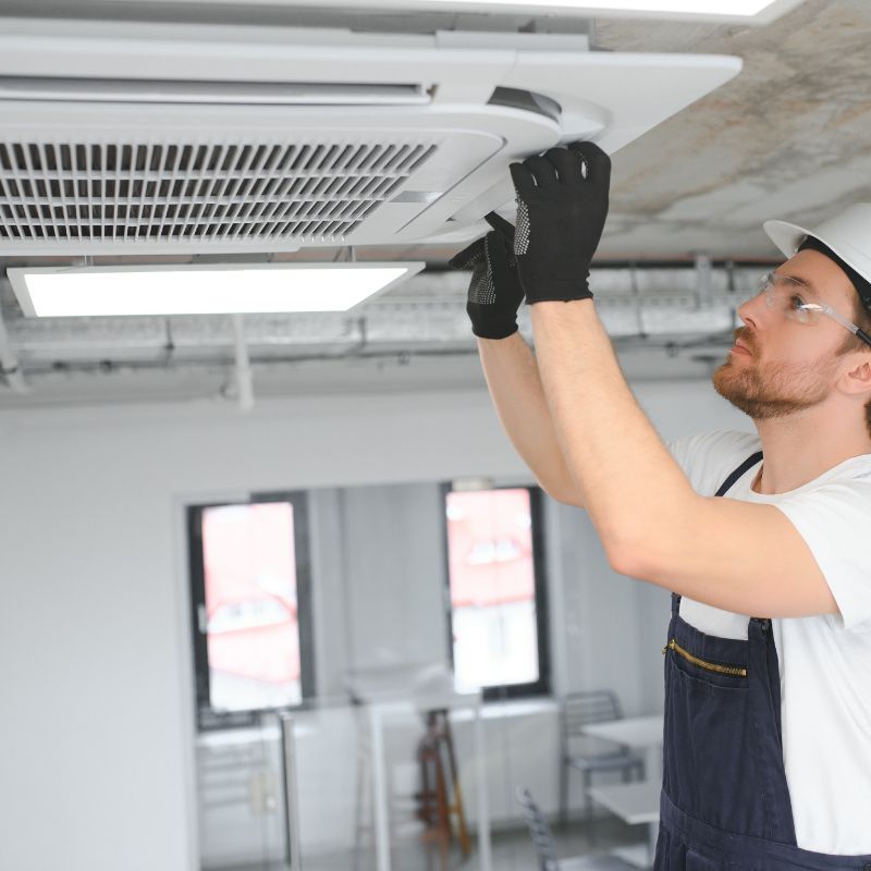 air conditioner engineer inspecting ceiling cassette air conditioner