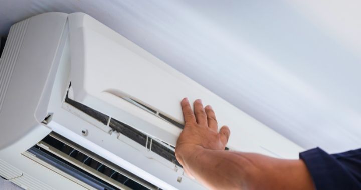 Person doing maintenance on a wall mounted air conditioning system