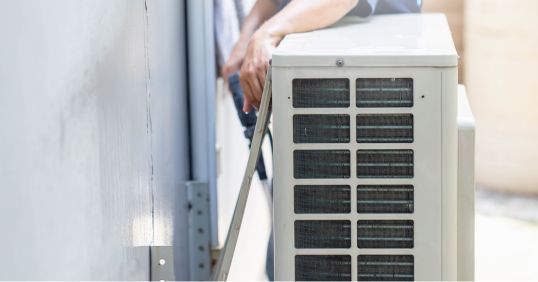 man fixing an outdoor air conditioning system