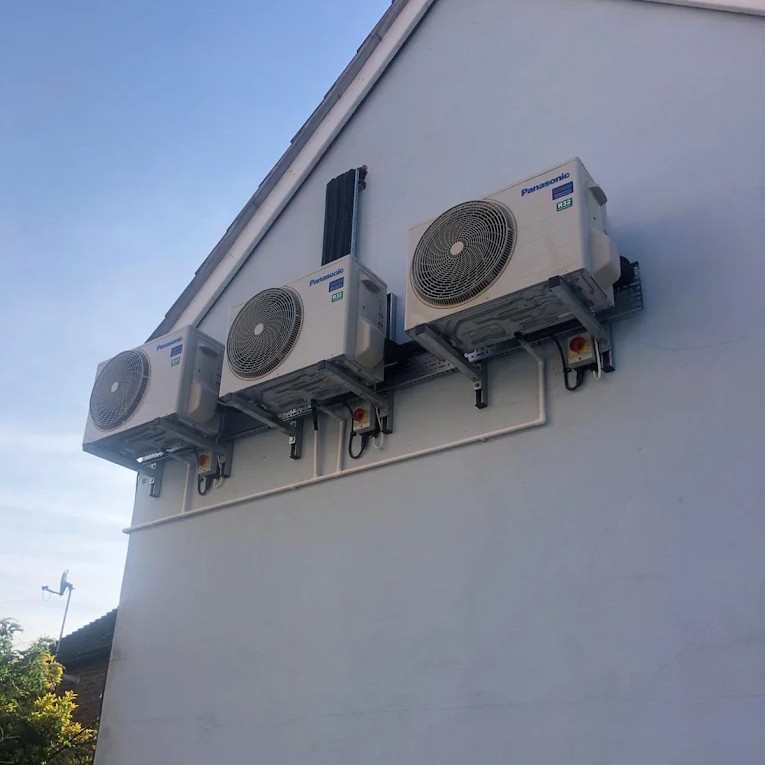 three panasonic outdoor ac units on side of house