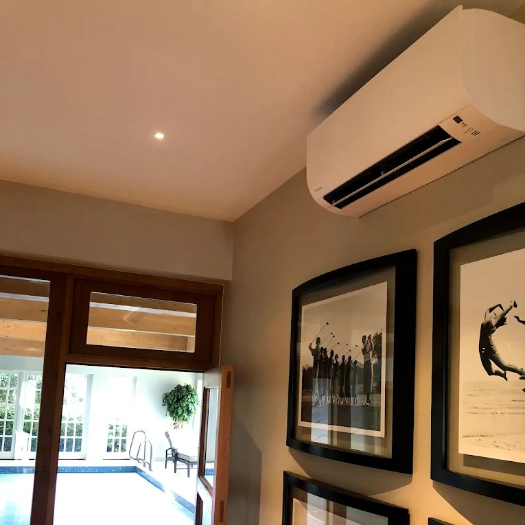 wall mounted air conditioner installed in house above picture frames